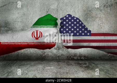 Konzept des Konflikts zwischen der Islamischen Republik Iran Und die Vereinigten Staaten von Amerika mit zwei gegnerischen Fäusten Vor einer Wand Stockfoto