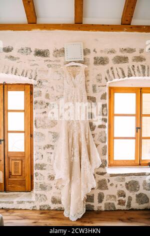 Brautjungfer Kleid mit einem Rock mit Volants vor dem Hintergrund einer Steinmauer und einem Holzfenster und Tür, im Inneren einer alten Villa. Stockfoto