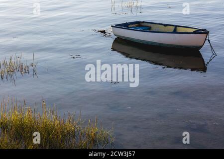 Ein altes Holzboot, das in einer ruhigen Marina festgemacht ist Stockfoto