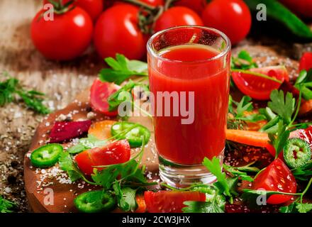 Frischer Saft aus der Mischung aus Gemüse mit Gemüse und Kräutern auf einem Holztisch, selektiver Fokus Stockfoto
