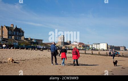 Portobello, Edinburgh, Schottland, Großbritannien. 27. September 2020. Nach dem jüngsten Regierungsratschlag, der die Öffentlichkeit auffordert, aktiv zu bleiben, um psychische Gesundheit und andere gesundheitliche Probleme zu vermeiden, scheinen die Menschen, die heute an der sonnigen Küste abgebildet sind, zu beachten, Abgesehen von einer Gruppe junger Menschen, die sich nicht bewusst zu sein scheinen, dass es notwendig ist, sich in kleinen Gruppen sozial zu distanzieren, während sie in einer Gruppe von fast einem Dutzend auf dem Sand sitzen. Herbstliches Wetter mit einer Temperatur von 4 Grad nach einer kalten Nacht und Morgen hat die Leute nicht in halten, da sie die geschäftige Atmosphäre genießen. Stockfoto