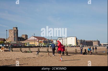 Portobello, Edinburgh, Schottland, Großbritannien. 27. September 2020. Nach dem jüngsten Regierungsratschlag, der die Öffentlichkeit auffordert, aktiv zu bleiben, um psychische Gesundheit und andere gesundheitliche Probleme zu vermeiden, scheinen die Menschen, die heute an der sonnigen Küste abgebildet sind, zu beachten, Abgesehen von einer Gruppe junger Menschen, die sich nicht bewusst zu sein scheinen, dass es notwendig ist, sich in kleinen Gruppen sozial zu distanzieren, während sie in einer Gruppe von fast einem Dutzend auf dem Sand sitzen. Herbstliches Wetter mit einer Temperatur von 4 Grad nach einer kalten Nacht und Morgen hat die Leute nicht in halten, da sie die geschäftige Atmosphäre genießen. Stockfoto