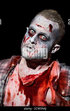 Zombie aus in der Nacht Wunden Schnitte und Blut befleckt zerrissene Kleidung, schlechte Zähne stechenden Augen bedrohende Haltung und Ausdruck im Hochformat. Stockfoto