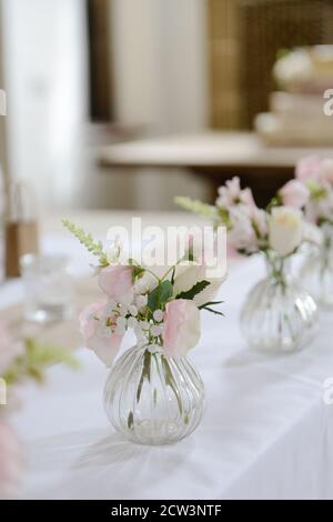 Rosa und weiße Blumen in mundgeblasenen Glasvasen Stockfoto