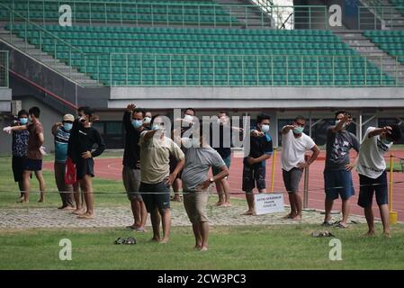 Bekasi, Indonesien. September 2020. Einige asymptomatische COVID-19-Patienten nehmen an den Morgenübungen außerhalb des Notheims im Stadion des Patriot Candrabagha-Komplexes in Bekasi, West Java, Indonesien, 27. September 2020 Teil. Die COVID-19-Fälle in Indonesien stiegen innerhalb eines Tages um 3,874 auf 275,213, wobei die Zahl der Todesopfer um 78 auf 10,386 stieg, teilte das Gesundheitsministerium am Sonntag mit. Quelle: Arya Manggala/Xinhua/Alamy Live News Stockfoto