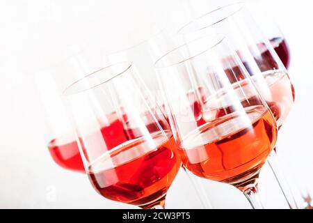 Roséweingläser mit Weinprobe. Verkostung verschiedener Sorten, Farben und Schattierungen von rosa Wein Konzept. Weißer Hintergrund Stockfoto
