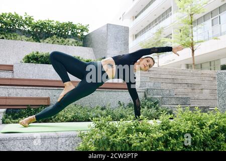 Frau tut Variation der wilden Sache Pose Stockfoto