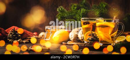 Winter oder Herbst heißen Heiltee mit Ingwer, Honig, Zitrone und Gewürzen in Glas Tasse mit Dampf, rustikalen Holzhintergrund Stockfoto