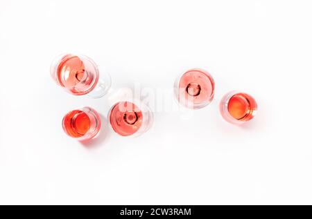 Roséweingläser bei Weinprobe. Degustation verschiedene Sorten von rosa Wein Konzept. Weißer Hintergrund, Draufsicht, hartes Licht Stockfoto