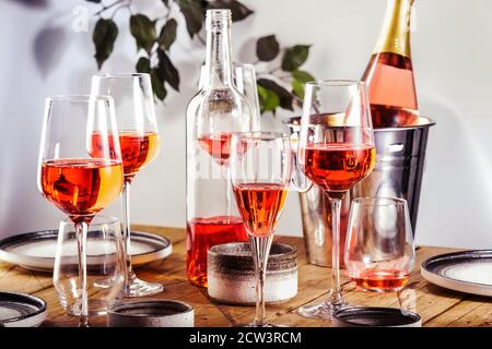 Roséwein Gläser und Flaschen auf dem Tisch serviert für festliche Dinner Party mit verschiedenen Arten von Vorspeisen und Obst Stockfoto