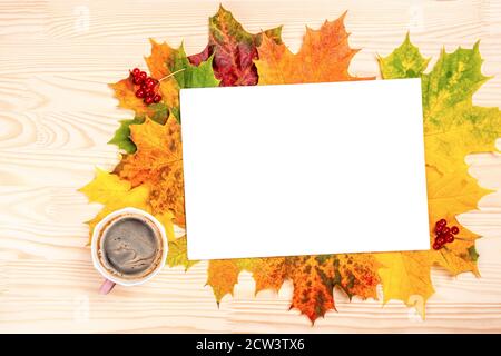 Mockup Blank Blatt Papier, Tasse heißen schwarzen Kaffee auf einem Hintergrund von hellen gefallenen Blättern liegen auf einem Holztisch. Herbst-Konzept. Flach legen, oben vi Stockfoto