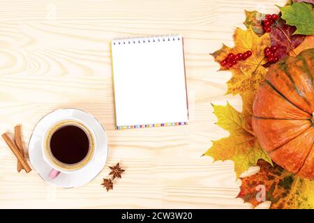 Mockup Herbst flach Lay Zusammensetzung. Tasse Kaffee, geöffnetes Papierheft, Zimtstangen, Herbstblätter auf weißem Holzschreibtisch. Herbst, Herbst Konzept. A Stockfoto