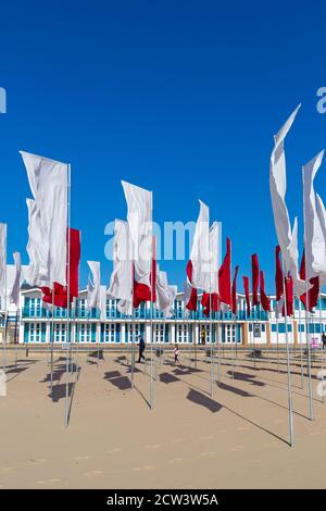 Sandbanks, Poole, Dorset, Großbritannien. September 2020. Die Menschen besuchen Luke Jerrams Kunstwerk "in Memoriam" am Strand von Sandbanks, das aus über 100 Bettlaken, einem riesigen Meer von Flaggen, geschaffen wurde, um an die Verlorenen von Covid-19 zu erinnern – Teil des Bournemouth Arts by the Sea Festivals. Die Installation ist in Form eines medizinischen Logos, eines roten Kreuzes auf weißem Hintergrund angeordnet und würdigt auch die mutigen Mitarbeiter und Freiwilligen des NHS, die weiterhin ihr Leben riskieren, um die Tausenden von Menschen zu versorgen, die vom Coronavirus betroffen sind. Quelle: Carolyn Jenkins/Alamy Live News Stockfoto