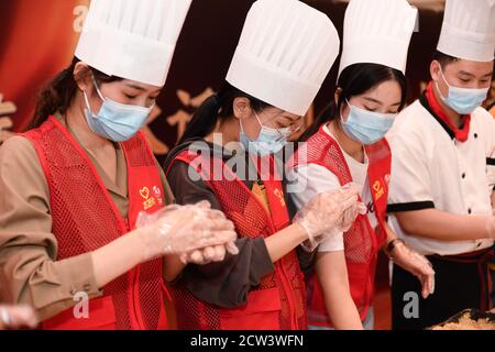 Huzhou, Chinas Provinz Zhejiang. September 2020. Freiwillige machen Mooncakes in Huzhou, ostchinesische Provinz Zhejiang, 27. September 2020. Freiwillige im Bezirk Nanxun in Huzhou machten Mondkuchen für ältere Menschen in Pflegeheimen und Sanitäranlagen, um ihre Grüße vor dem bevorstehenden Herbstfest auszudrücken. Quelle: Huang Zongzhi/Xinhua/Alamy Live News Stockfoto