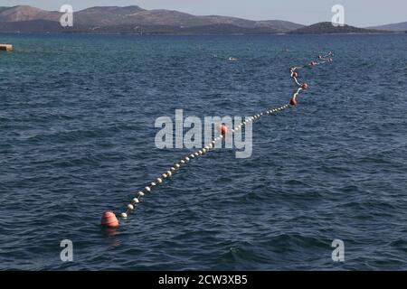 Seil mit Bojen, um einen sicheren Schwimmbereich abzuzäunen Am Strand Stockfoto