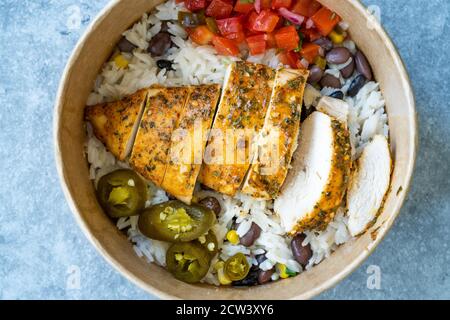 Take Away traditionelle mexikanische Tex-Mex-Essen mit Hackfleisch, Basmati-Reis, Huhn und Guacamole Sauce in Take Out Plastic Bowl. Bereit zum Servieren. Stockfoto