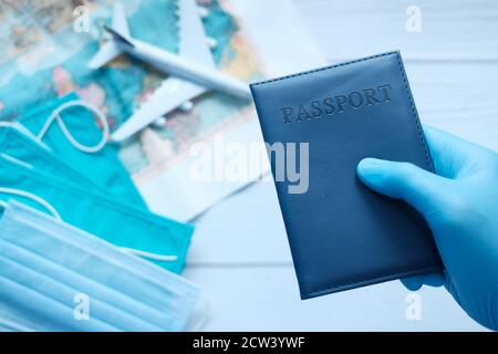Hand in blauen OP-Handschuhen mit Pass in der Hand. Stockfoto