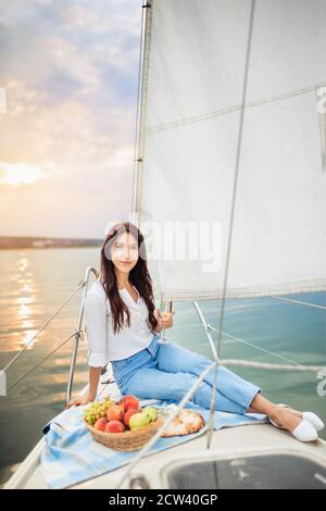 Frau mit einem Glas Champagner auf der Yacht Stockfoto