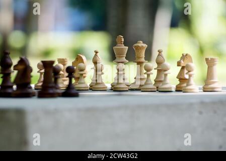 Holzschachfiguren stehen vor dem Outdoor-Turnier auf dem Schachbrett. Stockfoto