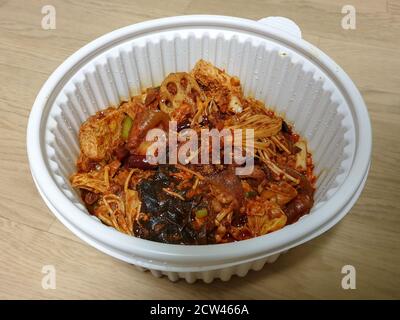 MA la xiang Pan oder Ma la xiang guo, ein chinesisches Gericht mit Fleisch und Gemüse. Würziger, betäubender Topf mit Rührbesen. Lebensmittel in der Plastikschüssel zum Mitnehmen. Stockfoto
