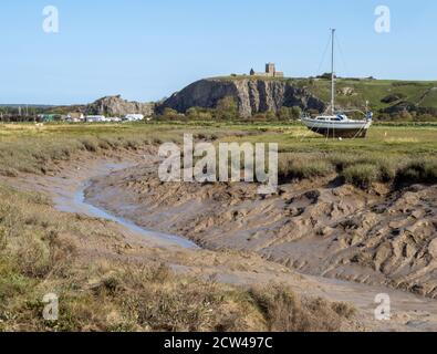 Schlammiger Bach der Axe mit bergauf Kirche Seine hohen Kalksteinfelsen in der Nähe von Weston super Mare in Somerset VEREINIGTES KÖNIGREICH Stockfoto