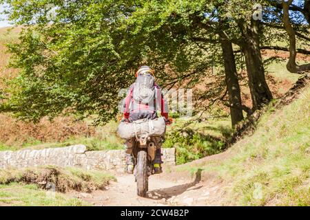 Off-Road-Motorradfahrer mit einer grünen Spur Weg überqueren die Steinbrücke an den drei Shires Kopf in der Spitze District National Park England Großbritannien Stockfoto