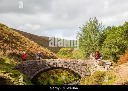 Off-Road-Motorradfahrer mit einer grünen Spur Weg überqueren die Steinbrücke an den drei Shires Kopf in der Spitze District National Park England Großbritannien Stockfoto