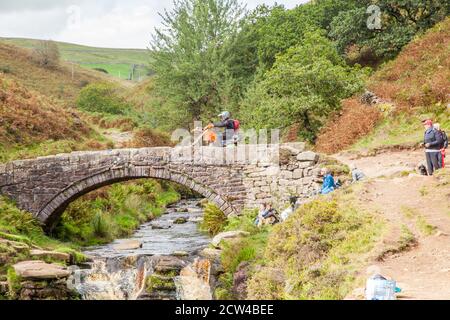 Off-Road-Motorradfahrer mit einer grünen Spur Weg überqueren die Steinbrücke an den drei Shires Kopf in der Spitze District National Park England Großbritannien Stockfoto