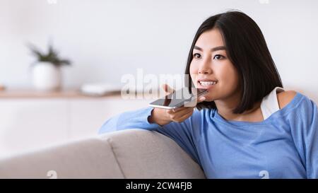 Junge Frau mit Voice Assistant auf dem Smartphone Stockfoto