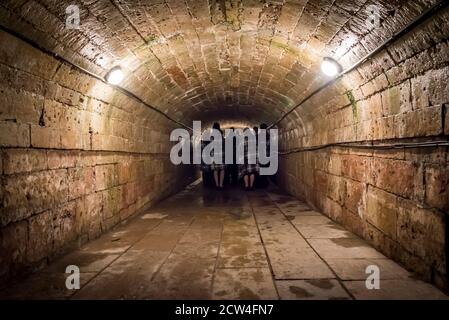 Dunkler unterirdischer Tunnel mit Menschen im Pawlowsker Palast bei Sankt Petersburg, Russland Stockfoto