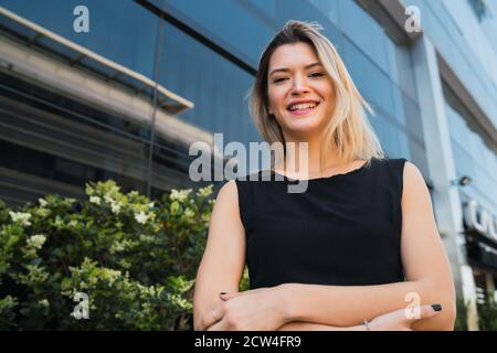 Porträt der jungen Geschäftsfrau, die außerhalb von Bürogebäuden steht. Geschäfts- und Erfolgskonzept. Stockfoto