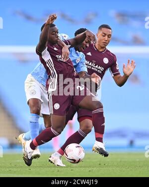 Raheem Sterling (Mitte) von Manchester City kämpft während des Premier League-Spiels im Etihad Stadium in Manchester gegen Nampalys Mendy (links) und Youri Tielemans von Leicester City. Stockfoto