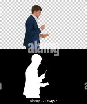 Denkender Geschäftsmann beim Gehen Notizen in sein Notizbuch schreiben Stockfoto