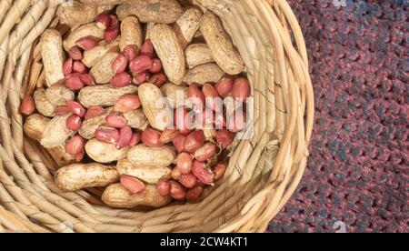 Erdnüsse wurden in einem Korb geschält und ungeschält. Stockfoto