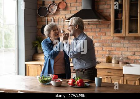 Glücklicher älterer Mann und Frau kochen zu Hause zusammen Stockfoto