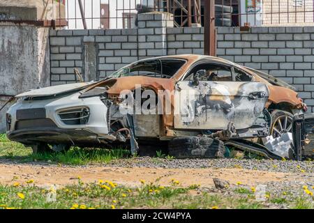 Verbranntes weißes fremdes Auto nahe der weißen Ziegelmauer. Feuerwehrauto. Stockfoto