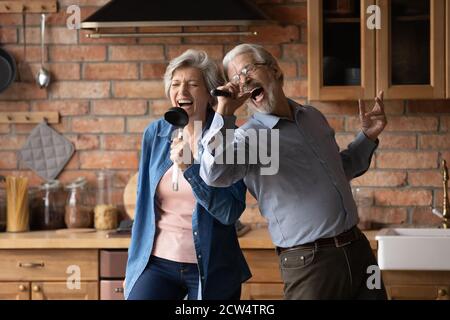 Überglücklich Senior Pärchen haben Spaß singen zu Hause Küche Stockfoto