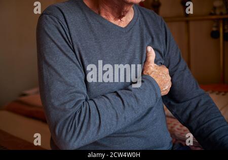 Nahaufnahme Von Senior Man Mit Gesundheitlichen Problemen Zu Hause Klammernden Brust In Schmerzen Stockfoto