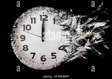 Zeit läuft aus Konzept zeigt Uhr, die sich in kleine Teilchen auflöst. Schwarz-weiße Wanduhr Stockfoto