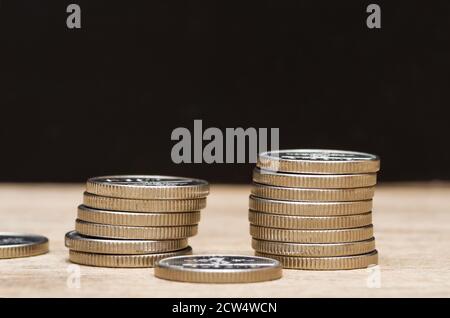 Viele Euro-Münzen auf schwarzem Hintergrund gestapelt. Stockfoto
