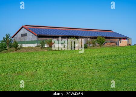 Grüner Energie mit Solarkollektoren auf dem Dach eines landwirtschaftlichen Gebäudes Stockfoto