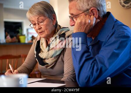 Seniorenpaar Zu Hause Am Tisch Sitzend, Persönliche Finanzen Prüfend Stockfoto