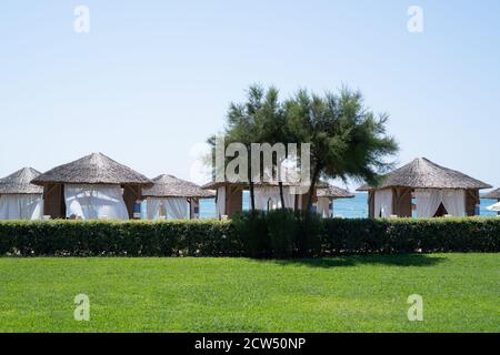 Vordächer am Strand. Luxuriöse Strandzelte. Hintergrund der Hotelwerbung. Sommerhaus Tapete. Sommerstrandkonzept Stockfoto