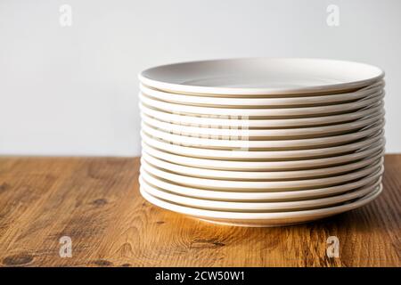Viele saubere weiße Teller Geschirr Küchenkleidung auf dem Tisch Stockfoto