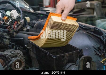 Ersetzen eines verstopften orangen Autoluftfilters während des allgemeinen Fahrzeugs Wartung mit einem Backup-Plan Stockfoto