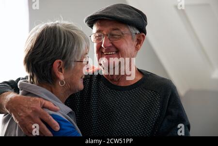 Liebende Ältere Paar Lachen Und Lächeln, Wie Sie Sich Gegenseitig Andere Zu Hause Zusammen Stockfoto