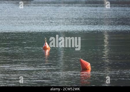 Leuchtend rote Boje in der Mitte des Meeres von blauem Wasser umgeben. Stockfoto