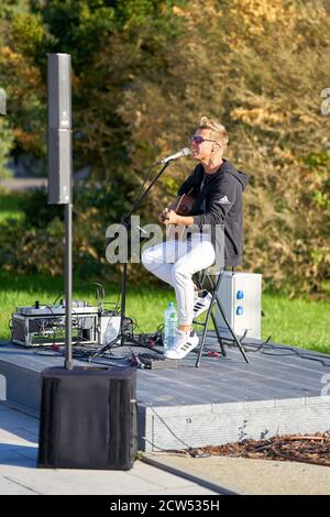 Junge Sängerin mit Gitarre auf der Strandpromenade von Swinoujscie In Polen Stockfoto