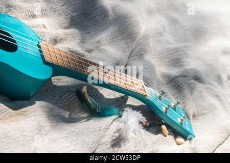 Nahaufnahme türkis Farbe Ukulele Gitarre Hals auf Leinen Tuch Hintergrund bei sonnigem Wetter Stockfoto