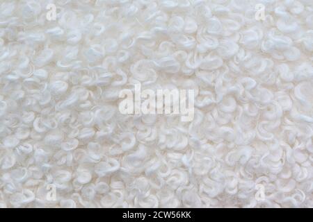 Die Textur der künstlichen weißen gewellten Wolle. Abstrakter weißer Hintergrund. Stockfoto